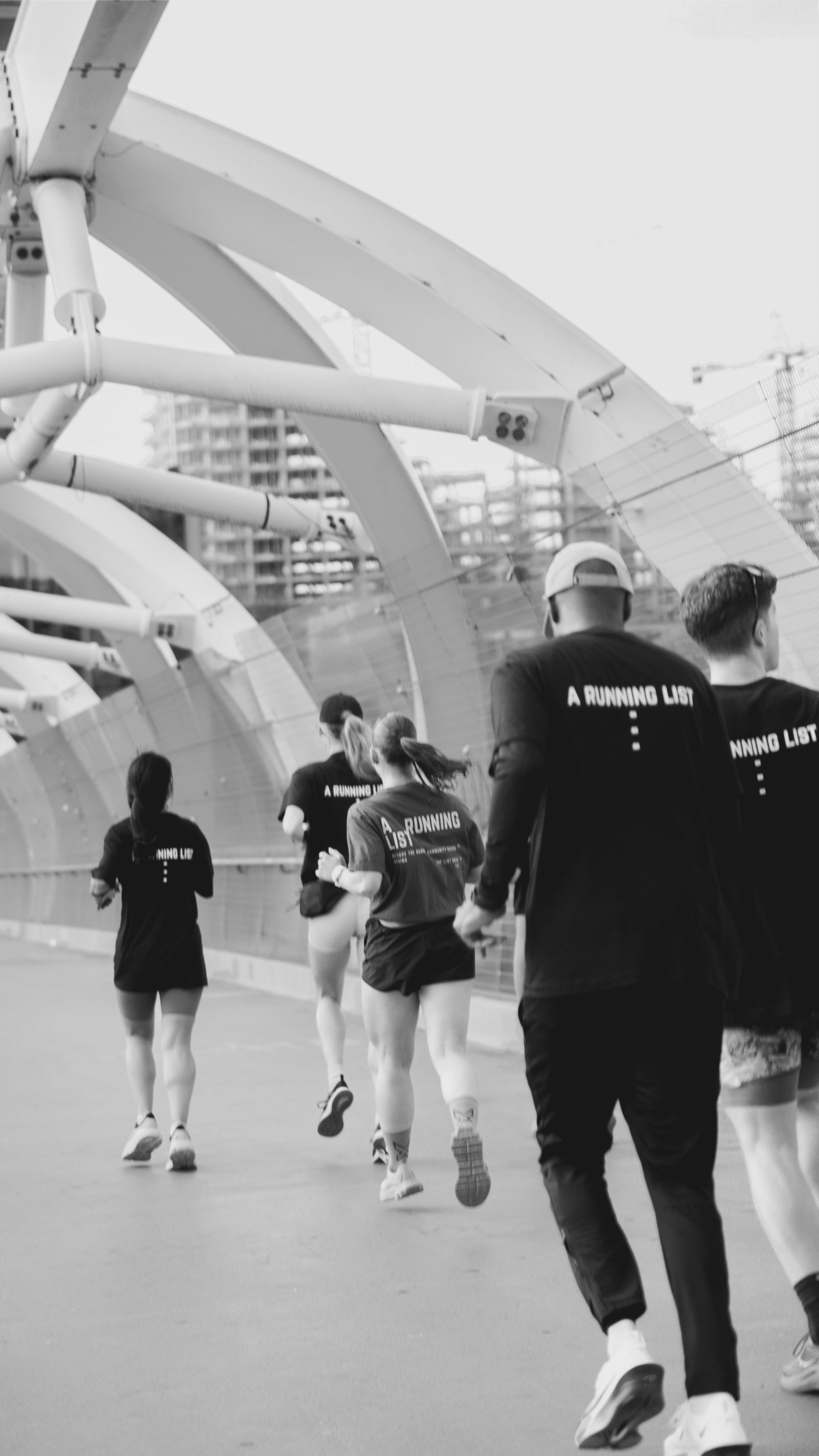 A Running List runners crossing a bridge